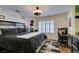Spacious bedroom with a dark bed frame, gray bedding, and work area at 5309 Silverheart Ave, Las Vegas, NV 89142