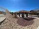 View of a community area with pergola, columns, desert landscaping, and a fenced perimeter at 5721 Heineken Dr, North Las Vegas, NV 89031