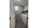 Well-lit laundry room with a washer, dryer, storage shelf and stylish gray vinyl flooring at 5721 Heineken Dr, North Las Vegas, NV 89031