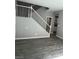 Open-concept living room featuring sleek gray wood floors and staircase with white bannister at 5721 Heineken Dr, North Las Vegas, NV 89031