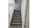 A staircase with white banister and gray treads leads to the upper level of the home at 5721 Heineken Dr, North Las Vegas, NV 89031