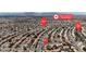 An aerial view of a residential neighborhood with numerous houses and streets, mountains in background, and nearby elementary school at 5850 Grey Wood Way, North Las Vegas, NV 89031