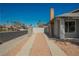 Wide driveway with gravel and concrete borders, palm trees visible beyond a white fence at 6284 Pinewood Ave, Las Vegas, NV 89103