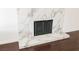 Close-up of modern white marble fireplace contrasting with the dark hardwood flooring at 6284 Pinewood Ave, Las Vegas, NV 89103