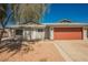Home with a large, two-car garage door and low-maintenance desert landscaping in the front yard at 6284 Pinewood Ave, Las Vegas, NV 89103