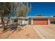 Home with a large, two-car garage door and low-maintenance desert landscaping in the front yard at 6284 Pinewood Ave, Las Vegas, NV 89103