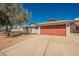 Home featuring a large, two-car garage door and low-maintenance desert landscaping in the front yard at 6284 Pinewood Ave, Las Vegas, NV 89103