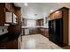 Gourmet kitchen with stainless steel appliances, dark wood cabinetry, and tile flooring at 6284 Pinewood Ave, Las Vegas, NV 89103