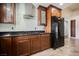 Featuring a black refrigerator and stainless steel gas stove with wood cabinets and tile flooring at 6284 Pinewood Ave, Las Vegas, NV 89103