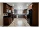 Updated kitchen featuring sleek black countertops, stainless steel appliances, and modern brown cabinets at 6284 Pinewood Ave, Las Vegas, NV 89103