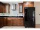 Featuring a black refrigerator and stainless steel gas stove with wood cabinets and tile flooring at 6284 Pinewood Ave, Las Vegas, NV 89103