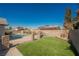 Backyard featuring a sparkling pool with a manicured lawn area and privacy fencing at 6284 Pinewood Ave, Las Vegas, NV 89103