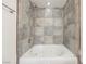 This bathroom features shower-tub combo with gray tile surround at 6284 Pinewood Ave, Las Vegas, NV 89103