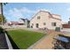 Large backyard with artificial turf, stone patio, gravel landscaping, and mature trees at 629 Newbridge Way, North Las Vegas, NV 89032