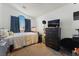 Cozy bedroom featuring a large window, carpeted floor, and a mounted television for entertainment at 629 Newbridge Way, North Las Vegas, NV 89032