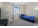 Clean bedroom with bright window, blue accents, carpet, and closet, offering a calm space at 629 Newbridge Way, North Las Vegas, NV 89032