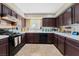 Traditional kitchen with white countertops, brown cabinets, tile flooring, and appliances at 629 Newbridge Way, North Las Vegas, NV 89032