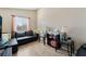 Bright living room with neutral walls, tile flooring, and a comfortable black leather sectional at 629 Newbridge Way, North Las Vegas, NV 89032