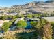 Aerial view of a single-story home with a pool and desert landscaping with mountain views in the background at 66 Golf Estates Dr, Las Vegas, NV 89141