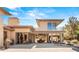 A spacious backyard with covered patio, outdoor dining, fireplace, and manicured landscaping perfect for outdoor living at 66 Golf Estates Dr, Las Vegas, NV 89141