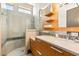 Bright bathroom with a glass-enclosed shower, wood vanity and modern fixtures at 66 Golf Estates Dr, Las Vegas, NV 89141