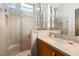 Bright bathroom with a glass-enclosed shower, wood vanity and modern fixtures at 66 Golf Estates Dr, Las Vegas, NV 89141