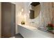 Stylish powder room featuring a stone accent wall, floating sink, and modern lighting fixtures at 66 Golf Estates Dr, Las Vegas, NV 89141