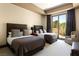Comfortable guest bedroom with two beds, neutral tones, and a view to the outside landscape at 66 Golf Estates Dr, Las Vegas, NV 89141