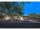 Elegant single-story home featuring desert landscaping, custom lighting, and a circular driveway at 66 Golf Estates Dr, Las Vegas, NV 89141