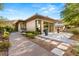 An elegant home exterior showing off the manicured landscaping and hardscape of the outdoor space and shuffleboard court at 66 Golf Estates Dr, Las Vegas, NV 89141