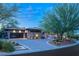 Modern home with a three-car garage, desert landscaping, and elegant lighting creating a welcoming ambiance at 66 Golf Estates Dr, Las Vegas, NV 89141