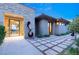 Contemporary home showcasing a stone accent wall, an artistic sculpture, and a tiled walkway leading to the entry at 66 Golf Estates Dr, Las Vegas, NV 89141