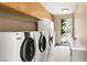 Bright laundry room with modern washer and dryer, storage cabinets, and access to the outdoors at 66 Golf Estates Dr, Las Vegas, NV 89141