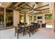 Covered outdoor dining area with a fireplace and TV, creating a perfect space for entertaining guests at 66 Golf Estates Dr, Las Vegas, NV 89141