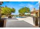 A backyard featuring a modern zero-edge pool with views, lush landscaping, and a large patio area for entertaining at 66 Golf Estates Dr, Las Vegas, NV 89141