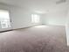 Large living room boasts neutral carpet, balcony access, and natural light from windows at 7482 Lodano Ave, Las Vegas, NV 89113