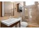 Modern bathroom featuring a glass enclosed shower, vanity with sink, toilet, and mirror at 7685 Gilespie St, Las Vegas, NV 89123