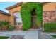 Inviting front exterior featuring a stone accents, lush landscaping, and a grand entryway at 7685 Gilespie St, Las Vegas, NV 89123