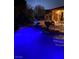 Inviting pool illuminated in blue, surrounded by patio furniture, perfect for evening relaxation at 7685 Gilespie St, Las Vegas, NV 89123