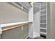 This closet has wooden bars and white shelving on a neutral tone wall at 8406 Belmont Valley St, Las Vegas, NV 89123
