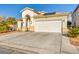 Front exterior featuring desert landscaping, a two-car garage, and a covered entryway at 8406 Belmont Valley St, Las Vegas, NV 89123