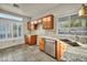 Well-lit kitchen featuring tile floors, light granite counters and wood cabinets at 8406 Belmont Valley St, Las Vegas, NV 89123