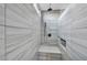 This walk-in shower features gray tile, bench, overhead shower head, and shower bar at 8406 Belmont Valley St, Las Vegas, NV 89123