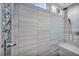 Walk-in shower features gray tile, bench, overhead shower head and shower bar at 8406 Belmont Valley St, Las Vegas, NV 89123
