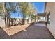 A sunny backyard features a concrete patio, a shade structure, and is enclosed by a beige cinderblock wall at 8732 Majestic Pine Ave, Las Vegas, NV 89143