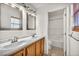 Bathroom with double sink vanity, matching mirrors, and an updated walk-in shower at 8732 Majestic Pine Ave, Las Vegas, NV 89143