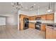 Bright kitchen with wood cabinets, black appliances, and a spacious tile floor at 8732 Majestic Pine Ave, Las Vegas, NV 89143