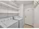 Well-lit laundry room equipped with washer, dryer, and shelving for organization at 8732 Majestic Pine Ave, Las Vegas, NV 89143
