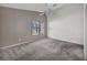The main bedroom features a ceiling fan, large window, and neutral-colored walls and carpet at 8732 Majestic Pine Ave, Las Vegas, NV 89143
