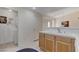 Bright bathroom with wooden cabinets and a sink; laundry area is conveniently located nearby at 908 Domnus Ln # 203, Las Vegas, NV 89144